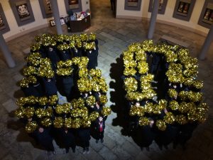 Human Formation of the number 50 made with gold pom poms
