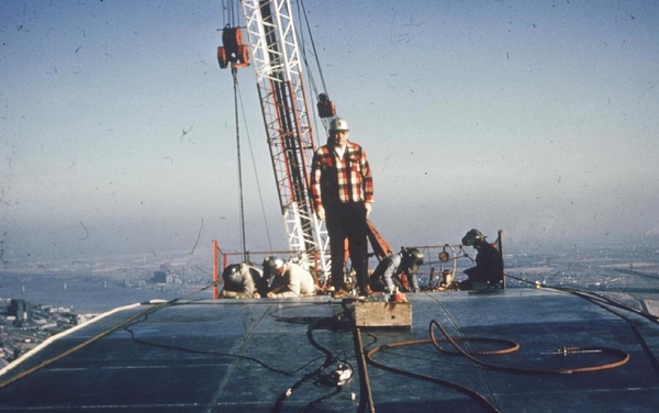 Construction workers standing atop the Gateway Arch in 1965.