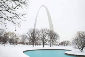 Gateway Arch with snow covering the grounds.
