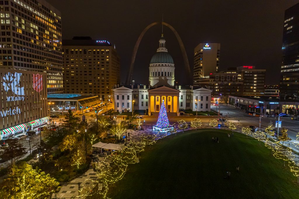 Holiday lights adorn the trees of Kiener Plaza in downtown St. Louis for Winterfest 2020. The Old Courthouse and Gateway Arch stand in the background.