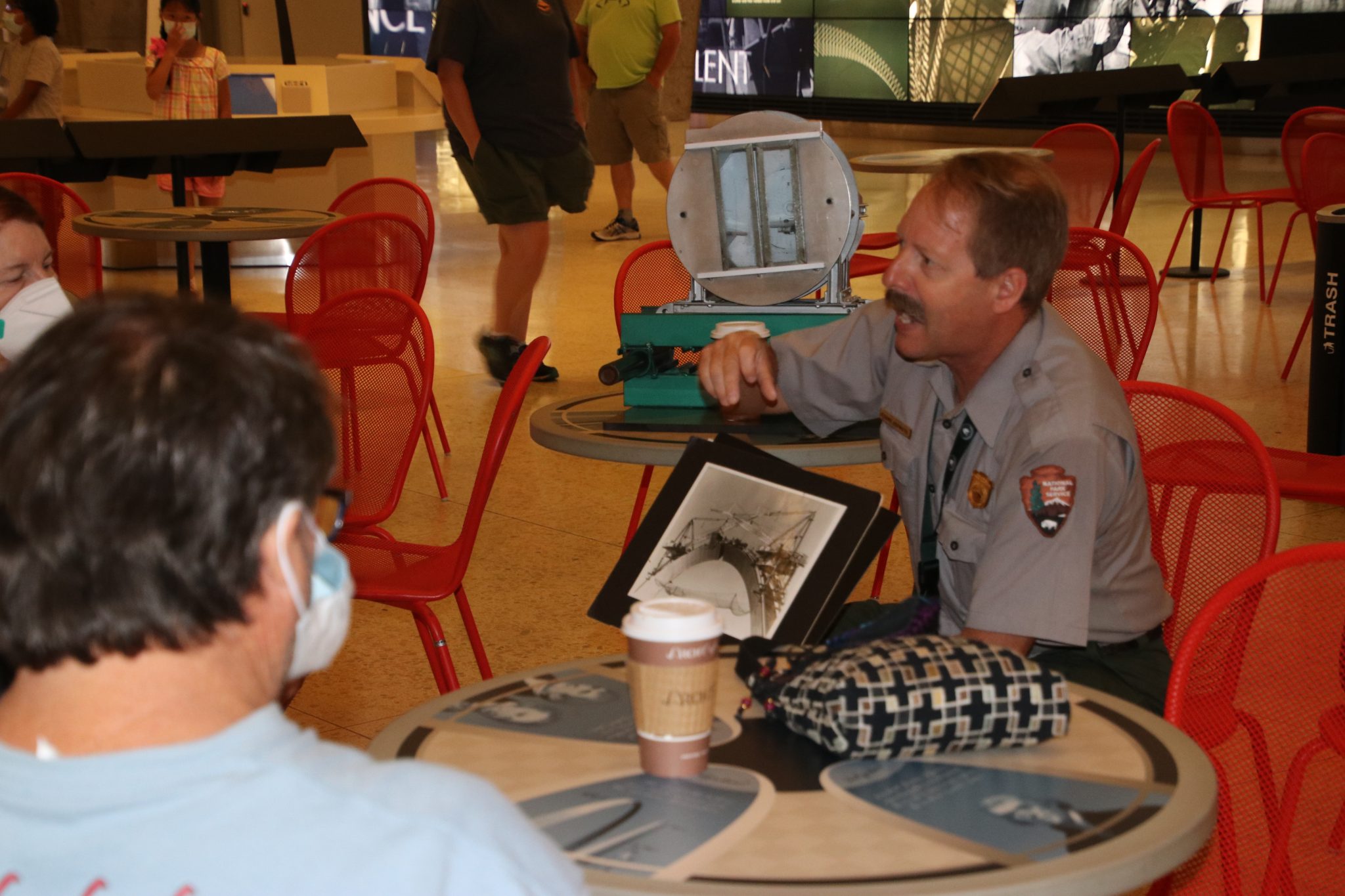 A National Park Service Ranger holds a photo of the construction of the Gateway Arch and speaks to guests during a Coffee with a Ranger event at Gateway Arch National Park. (Photo provided by NPS)