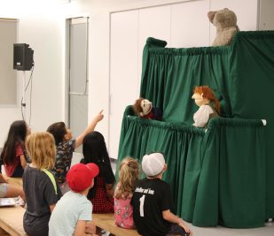National Park Service Rangers put on a puppet show for a group of children inside the Education Center at Gateway Arch National Park. (Photo provided by NPS)
