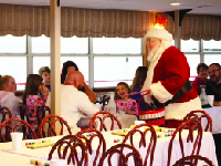 A family with four young children get a visit from Santa aboard a PJ's and Pancakes cruise on the Riverboats at the Gateway Arch.