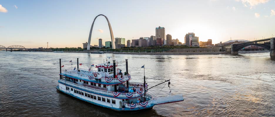 Riverboat on the Mississippi River with the St. Louis skyline and Gateway Arch in the background.