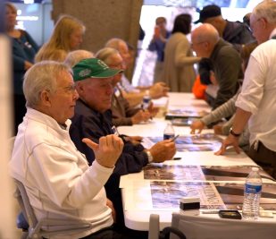 Builders of the Gateway Arch sit behind a table and talk with visitors during the annual Meet the Builders event at the Arch.