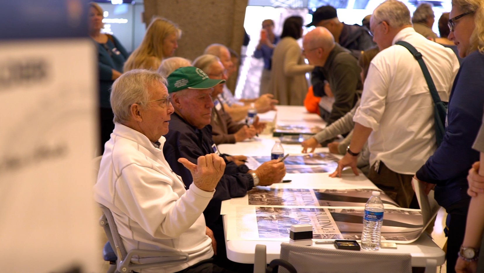 Builders of the Gateway Arch sit behind a table and talk with visitors during the annual Meet the Builders event at the Arch.