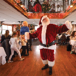 Santa Clause poses for a photo on the Riverboats at the Gateway Arch during a PJs and Pancakes Cruise.