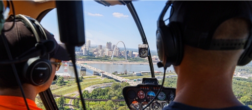 Two people inside of a helicopter over St. Louis.