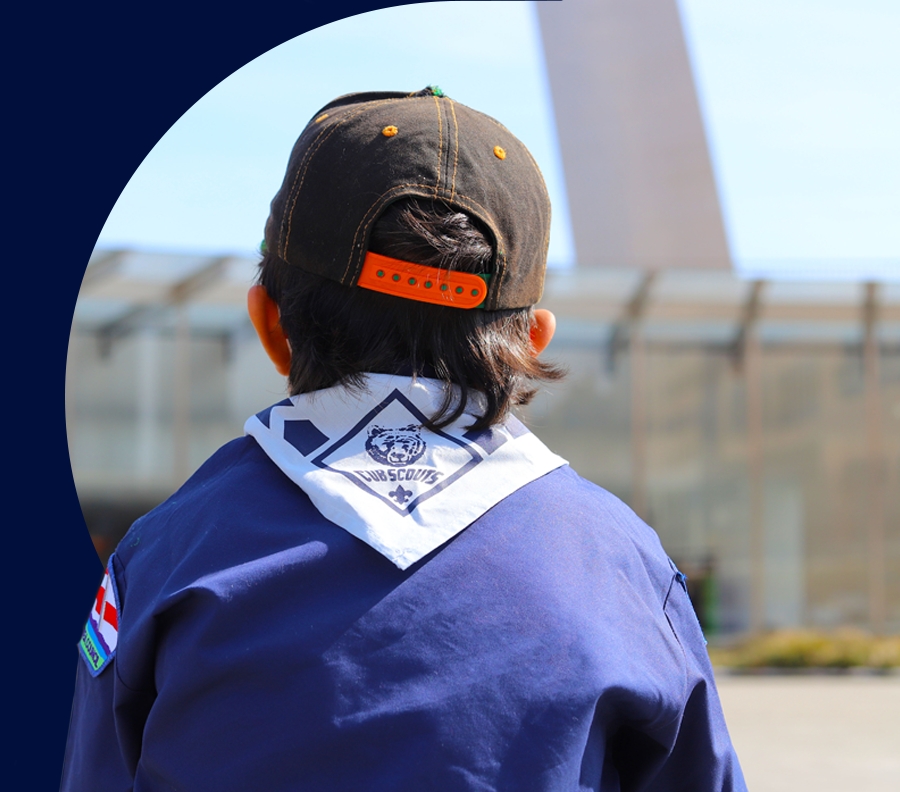 Boy wearing a cub scouts uniform facing the Gateway Arch.