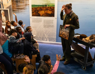 A diverse group of students listen to a Ranger in the Museum at Gateway Arch National Park