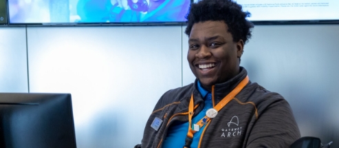 Smiling Gateway Arch employee at ticket sales desk.