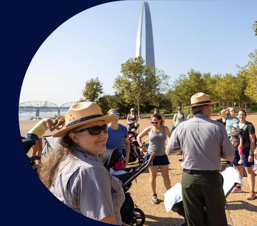 Two Gateway Arch National Park Rangers lead a group on a walking tour