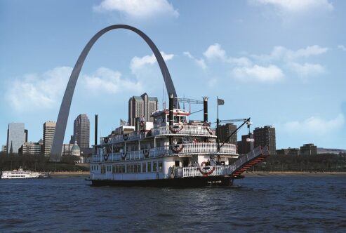 The Tom Sawyer Riverboat cruises the Mississippi River in front of the Gateway Arch and St. Louis skyline