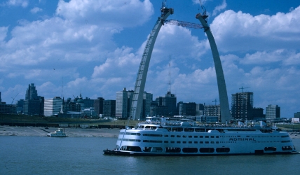 The completed "Admiral" cruise ship cruises past an almost completed Gateway Arch.