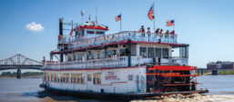 Tom Sawyer riverboat leaving the dock and cruising up the Mississippi River.