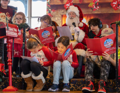 Children sit around Santa as they all sing Christmas songs during a Caroling with Santa Cruise on the Riverboats at the Gateway Arch