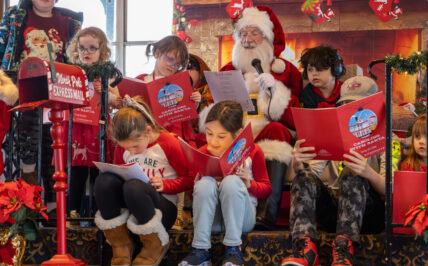 Children sit around Santa as they all sing Christmas songs during a Caroling with Santa Cruise on the Riverboats at the Gateway Arch