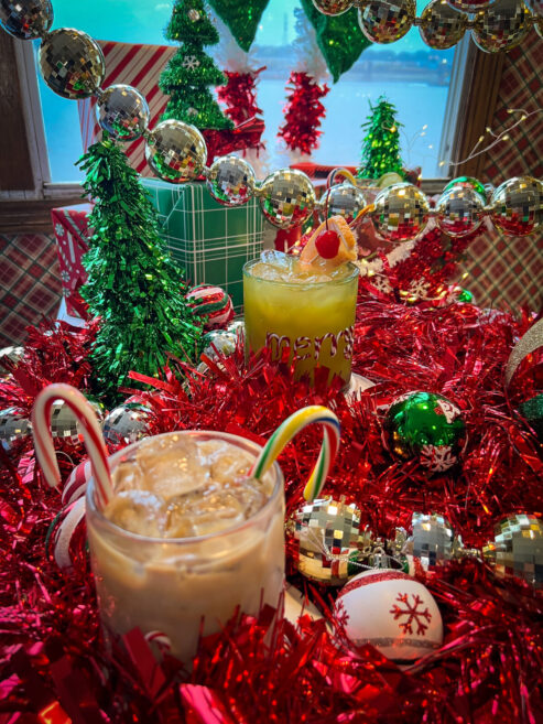 Holiday drinks from The Floating Sleigh pop-up bar displayed on with Christmas decor everywhere on the Tom Sawyer Riverboat