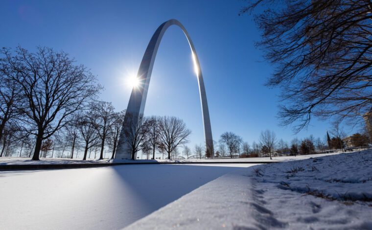 snow covered ground with the Gateway Arch in the background