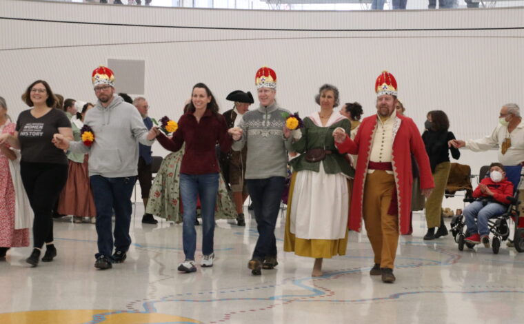 Living history performers dressed in 1770s attire perform dances popular in St. Louis in the 1770s inside the Gateway Arch Visitor Center