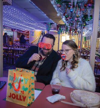 A couple takes a festive, silly photo on The Floating Sleigh.
