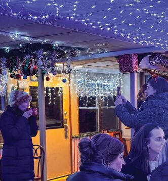 A group of people drinking, chatting and hanging around on The Floating Sleigh.