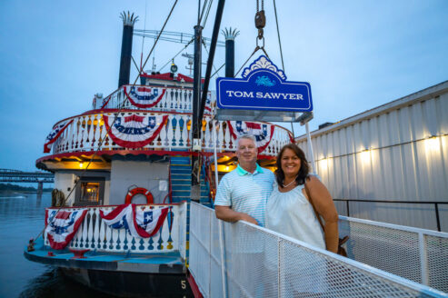 Couple poses for a photo while boarding the Tom Sawyer riverboat for a Skyline Dinner Cruise
