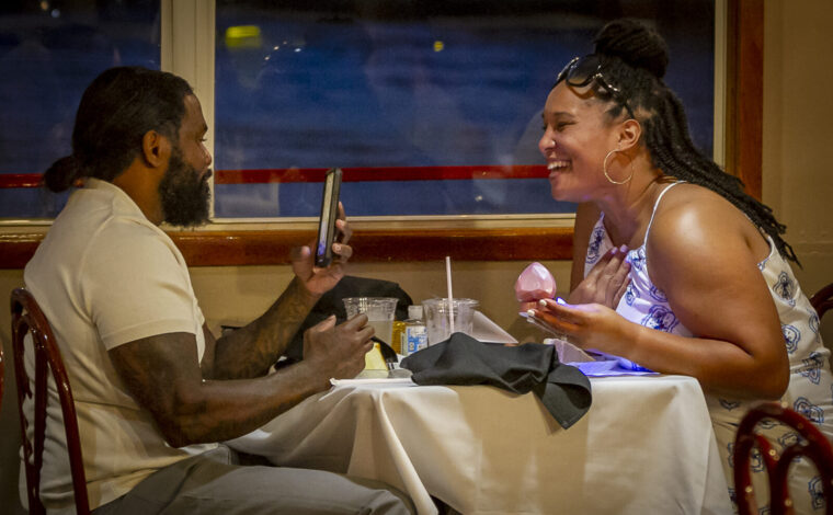 A couple laughs during dinner aboard the Tom Sawyer riverboat during a Skyline Dinner Cruise