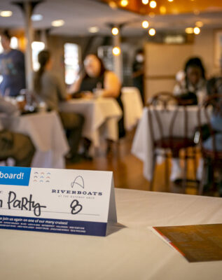 Table tent on a dinner table aboard the Tom Sawyer riverboat during a Skyline Dinner Cruise