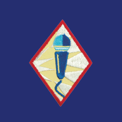 image of Girl Scout Public Speaker Badge, Badge has a red border and a microphone.